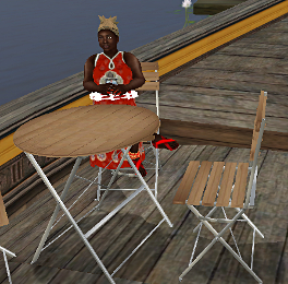 Iyoba sits at a table on a ship in the harbor on Tuamk